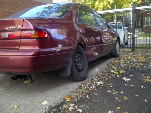 1999 maroon toyota camry with many miles, a good engine, and a damaged wheel
