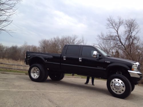Black ford lifted dually super duty monster truck show truck on semi tires f-350