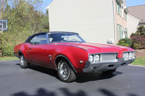 1969 convertible, red with black top and interior, bucket seats with console